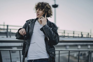 Rahat stil sahibi bir adam telefonda konuşuyor.