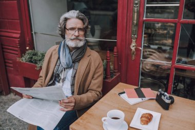 Gazetesi olan düşünceli bir adam.