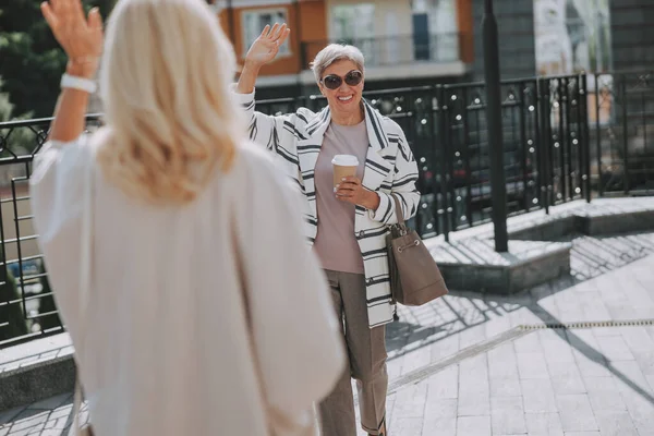 Mujer despidiéndose de su alegre amiga — Foto de Stock