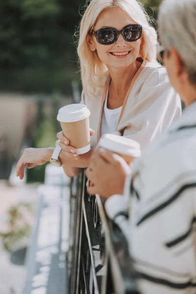 Iloinen valkoihoinen nainen puhuu hänen ystävänsä kanssa — kuvapankkivalokuva