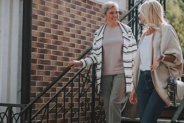 Two pleased women talking on the stairs — Stock Photo, Image