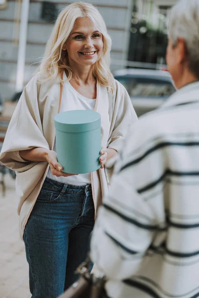 Mujer guapa dando un regalo a un amigo — Foto de Stock