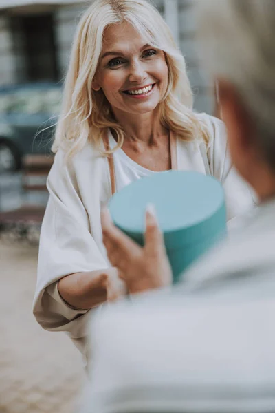 Happy attractive Caucasian lady giving a gift — Stock Photo, Image