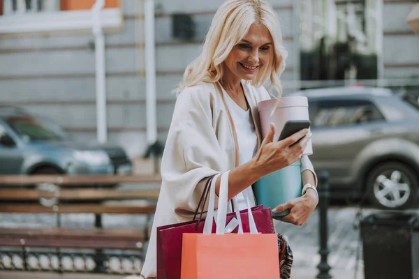 Wesoły stylowy pani patrząc na jej smartfon — Zdjęcie stockowe