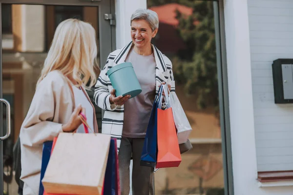 Mulher com sacos de compras olhando para seu amigo — Fotografia de Stock