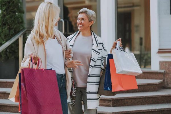 Felices damas de moda sonriéndose mutuamente — Foto de Stock