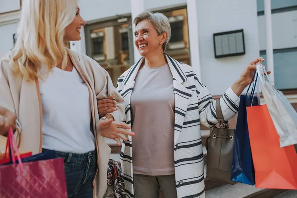 Feminino olhando para seu amigo com compras — Fotografia de Stock