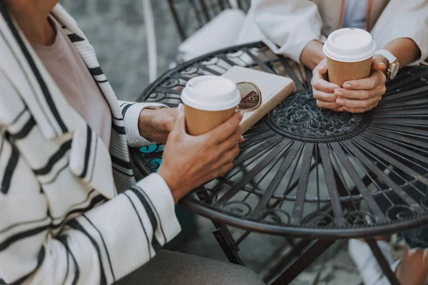 Dos mujeres sosteniendo tazas de papel de café — Foto de Stock