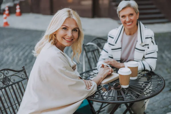 Dos amigos tomados de la mano en un café — Foto de Stock