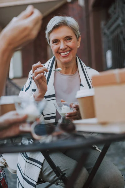 Fröhliche Frau genießt ein Vanille-Dessert in einem Café — Stockfoto