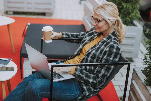 Freelancer usando su laptop en un café — Foto de Stock