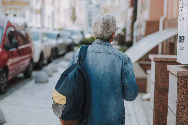Пожилая белая женщина идет по тротуару — стоковое фото