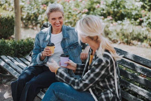 Kvinna som sitter med en vän i en park — Stockfoto