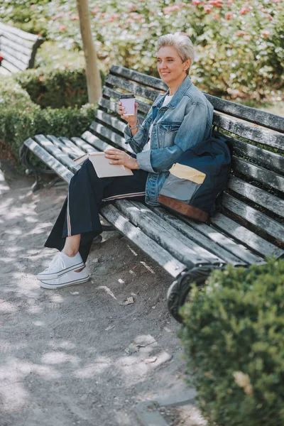 Mujer con un libro sentado en el banco — Foto de Stock