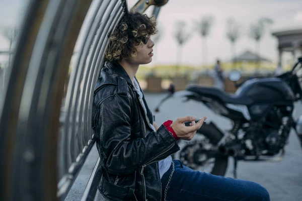 Tipo despreocupado teniendo cigarrillo cerca de motorbice al aire libre stock foto — Foto de Stock