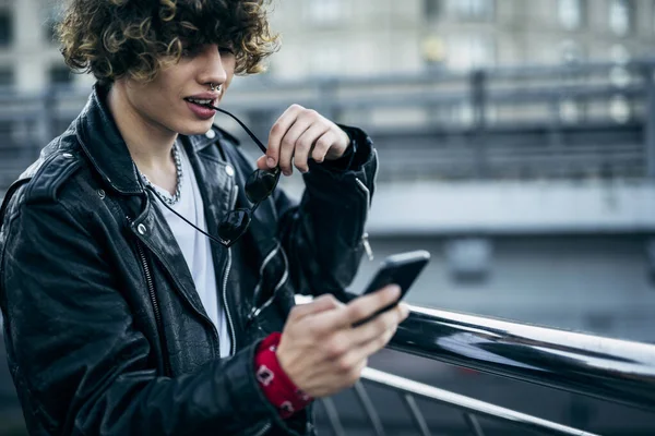 Brutal joven con teléfono inteligente al aire libre stock foto — Foto de Stock