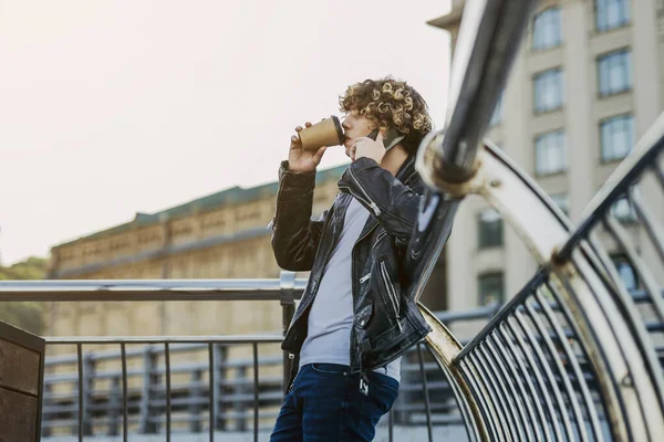 Chico con café charlando en el teléfono al aire libre stock foto —  Fotos de Stock