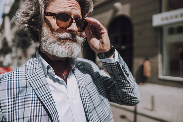 Bärtiger älterer Mann berührt Sonnenbrille Archivfoto — Stockfoto