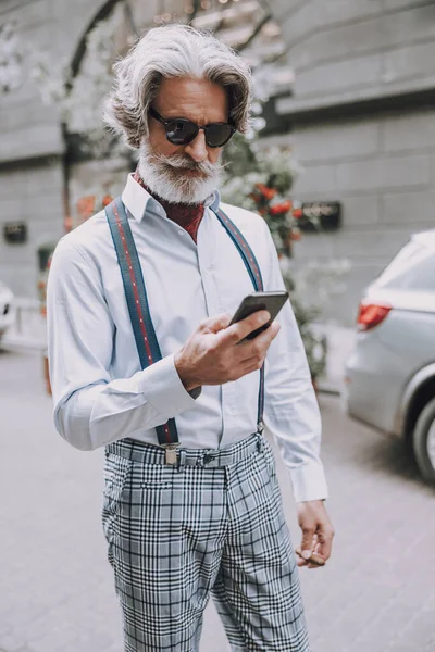 Sourire homme mûr avec smartphone en plein air photo de stock — Photo