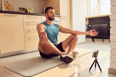 Yakışıklı beyefendi evde online eğitim sırasında meditasyon yapıyor.