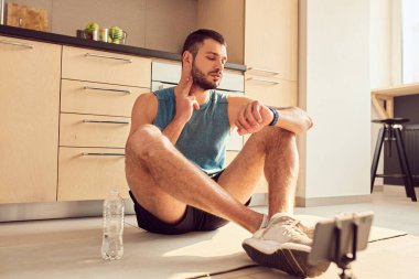 Evde nabız ölçen yakışıklı bir genç.