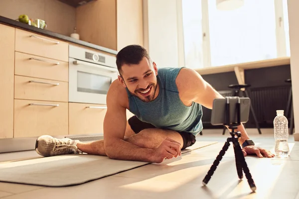 Guapo joven tomando clases de entrenamiento en línea — Foto de Stock