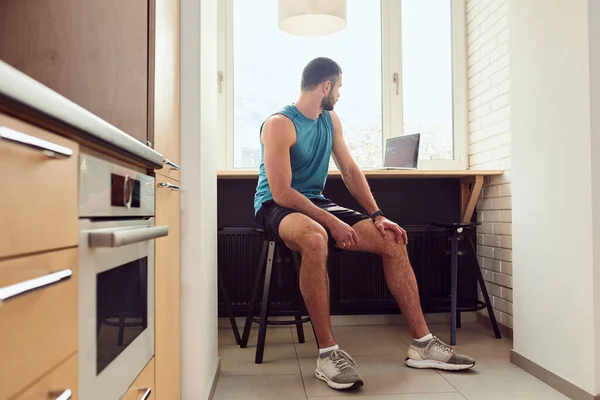 Atlético joven que utiliza el ordenador portátil moderno en casa — Foto de Stock