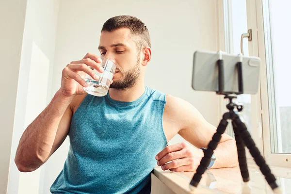 Guapo joven bebiendo vaso de agua en casa — Foto de Stock