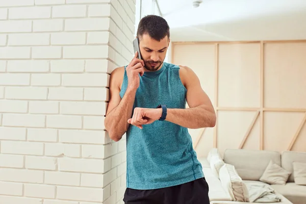 Guapo caballero tener conversación telefónica y comprobar el tiempo — Foto de Stock