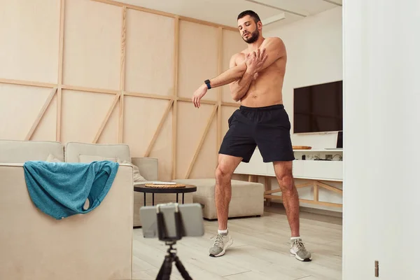 Atletický džentlmen bez košile cvičí v obýváku — Stock fotografie