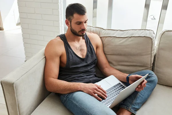 Joven serio trabajando en el ordenador portátil en casa — Foto de Stock