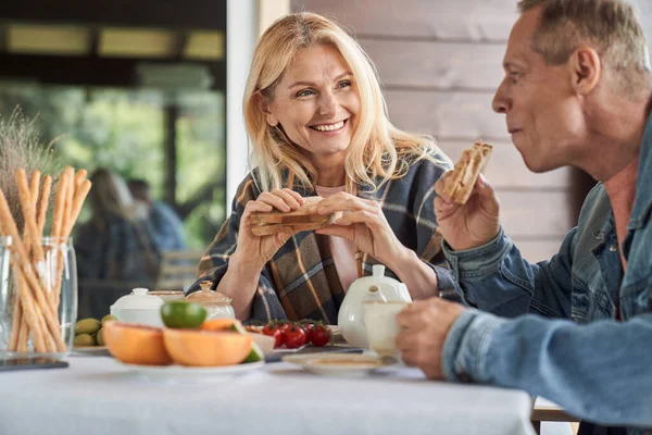 Happy elderly spouses enjoying meals in veranda — Stock Photo, Image