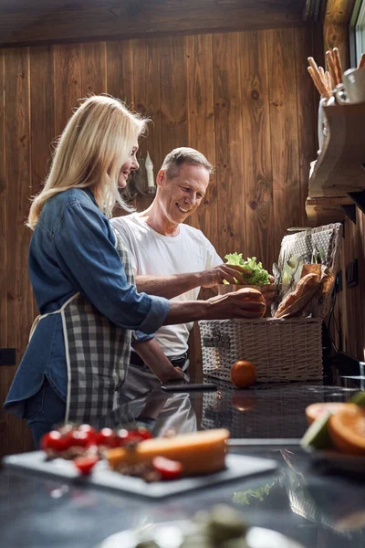 Glimlachen volwassen paar verpakking voedsel voor picknick — Stockfoto