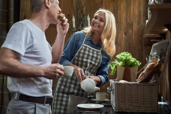 Lycklig kvinna gör te för älskad make — Stockfoto