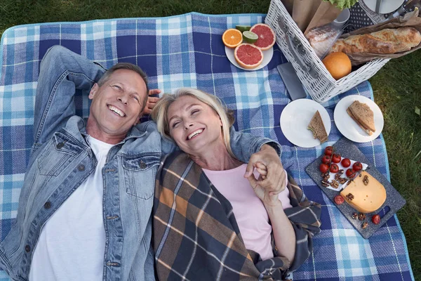 Счастливая зрелая пара отдыхает во время пикника на природе — стоковое фото