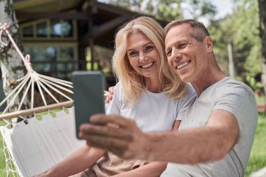 Mutlu eşler yeşil bahçede selfie çekiyor