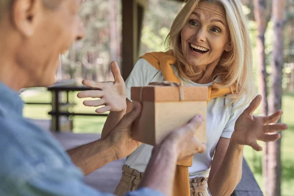 Man presenteren geschenk aan verrast vrouw op terras — Stockfoto