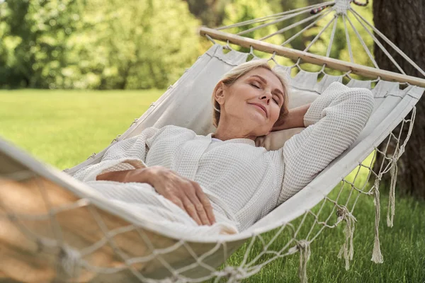 Happy mature female sleeping in hammock outdoors — Stock Photo, Image