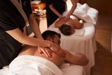 Spa salonundaki iki genç için eş zamanlı masaj.