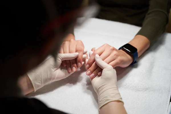 Professionell nageltekniker hålla händerna på sin klient — Stockfoto