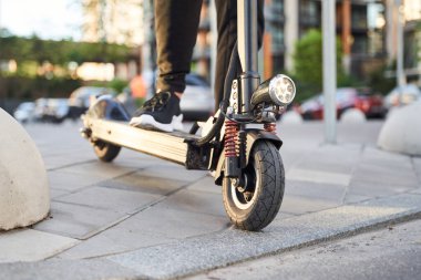 Şehirden elektronik scooterla geçen bir erkek.