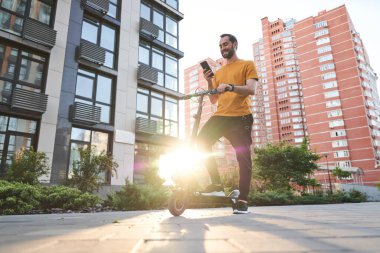 Motorlu ve cep telefonlu mutlu genç adam.