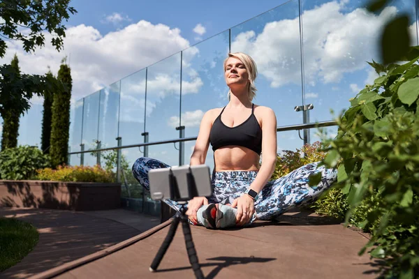 Självsäker glad kvinna som spelar in sin yogaträning — Stockfoto