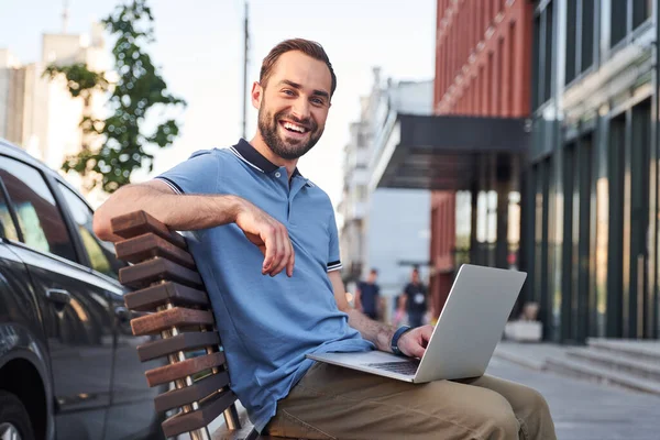 Homem barbudo alegre com laptop na rua urbana — Fotografia de Stock
