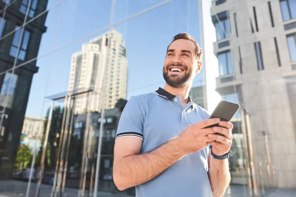 Gelukkig jongeman messaging op mobiele telefoon buiten — Stockfoto