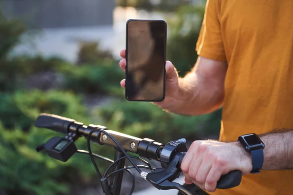 Jinete masculino mostrando la pantalla táctil del teléfono al aire libre —  Fotos de Stock