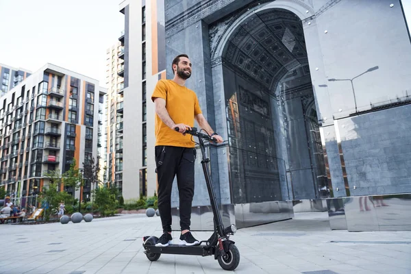Gelukkige jongeman die ecologisch elektronisch transport in de stad gebruikt — Stockfoto