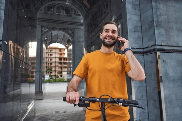 Счастливый парень звонит во время езды по городу — стоковое фото