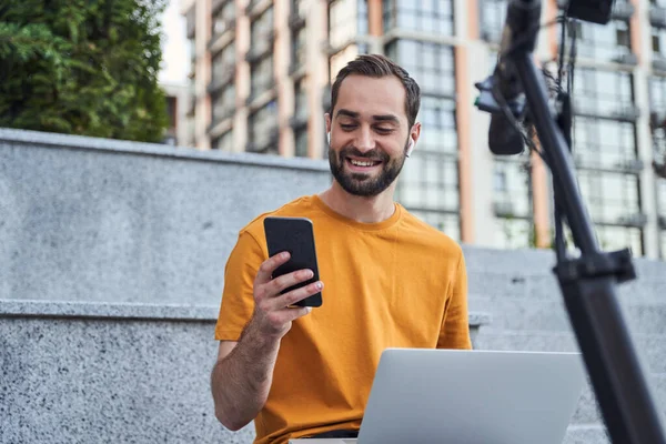 Sorrindo homem com gadgets digitais na cidade — Fotografia de Stock