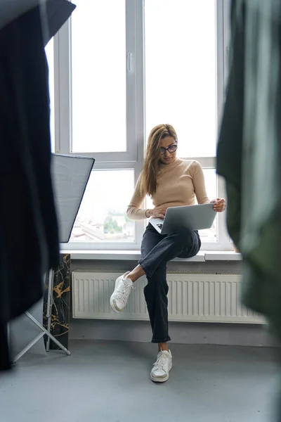 Mujer feliz trabajando en línea desde el estudio de moda — Foto de Stock